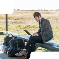 A guy working with his notebook on a hill