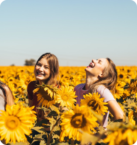 Two ladies laughing in sunflower field